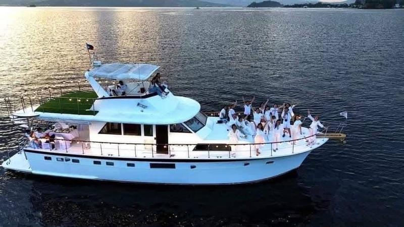 Large yacht with guests on deck at sunset