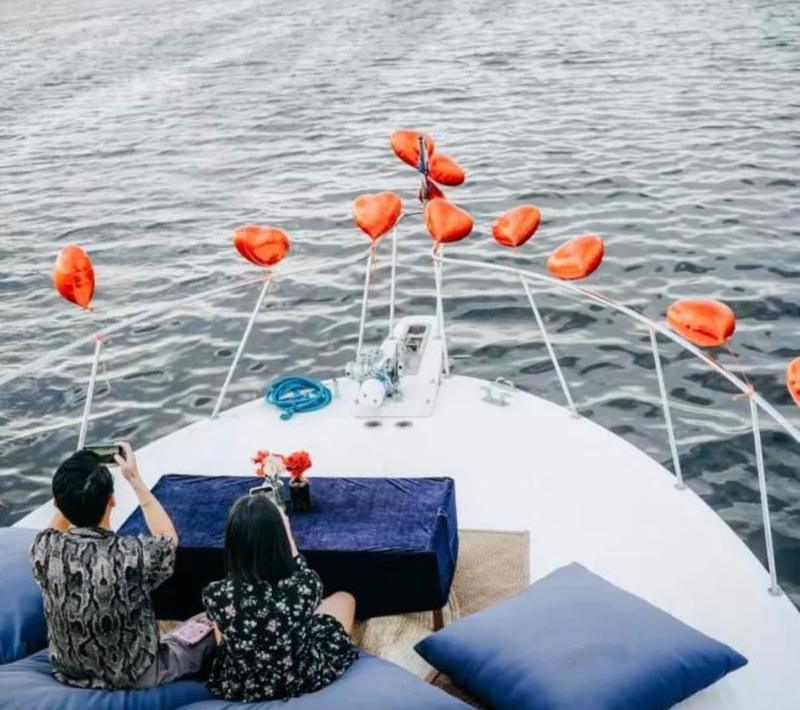 Couple on the bow of a yacht with balloons
